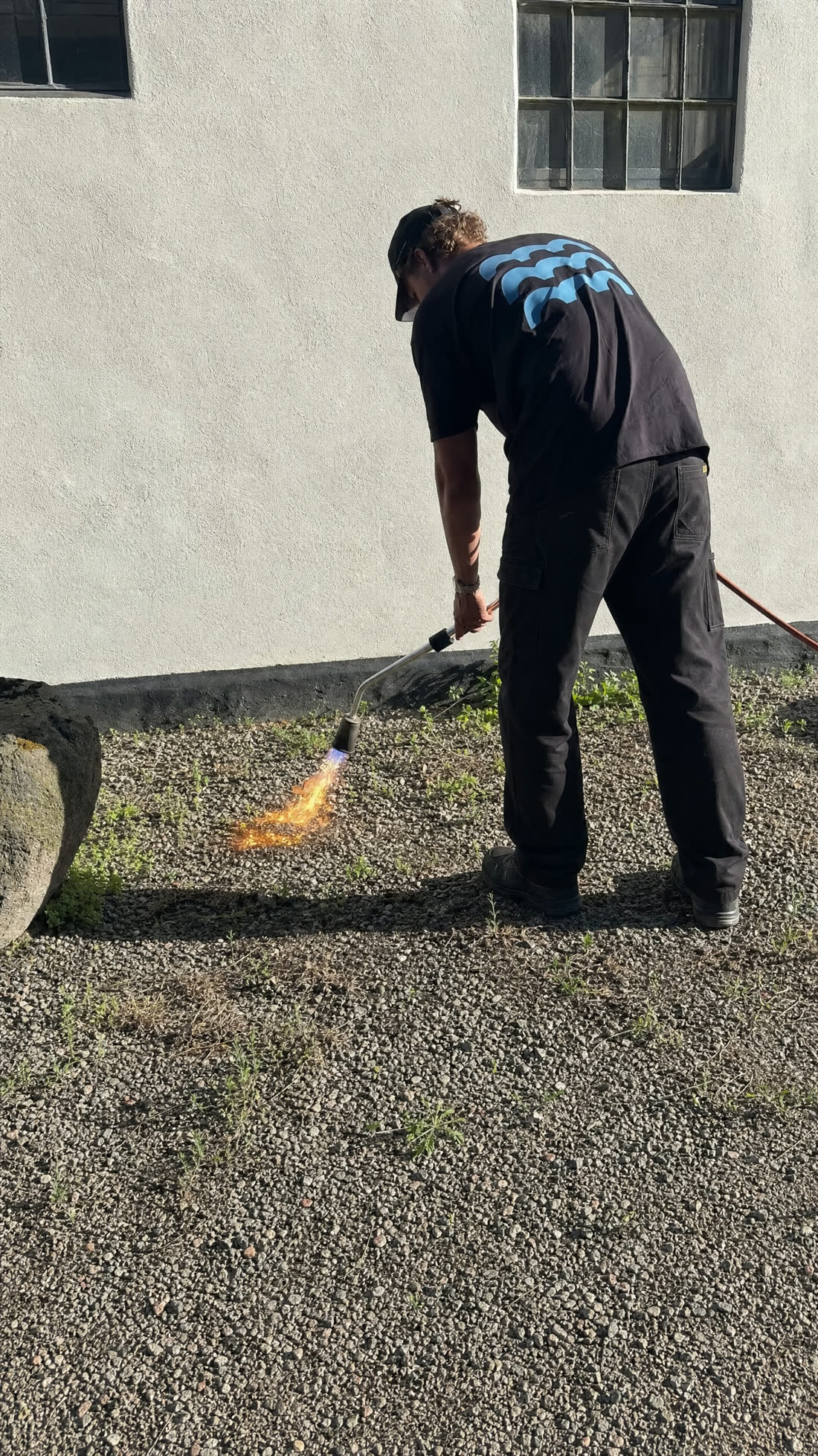 Ukrudtsbekæmpelse med gasbrænder på gårdareal, uden sprøjtegift